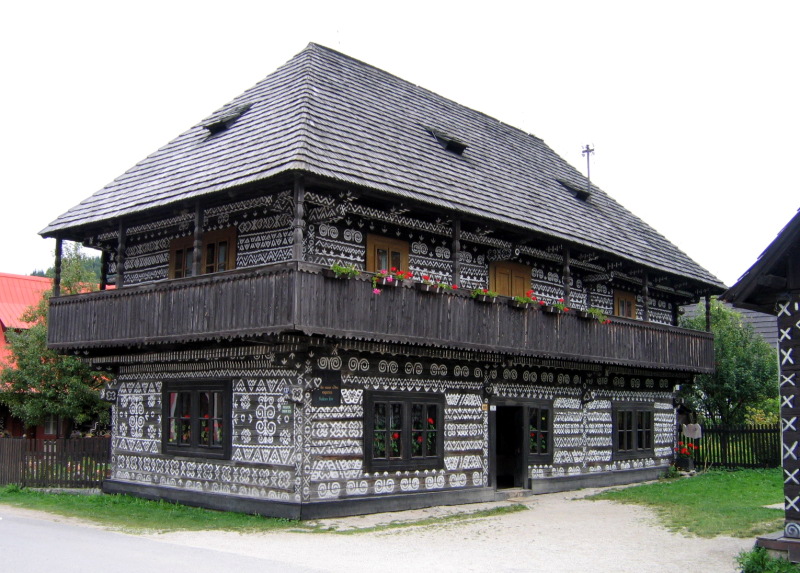zdobený drevený dom s bielou výzdobou ľudovej architektúry zo Slovenska