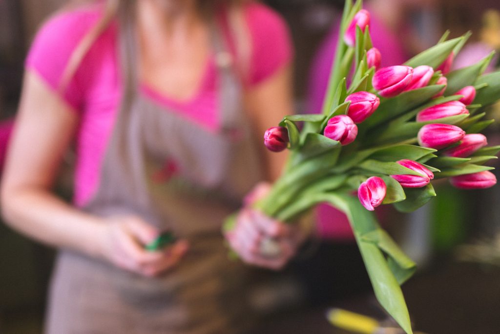 mladá žena drží v ruke kyticu tulipánov