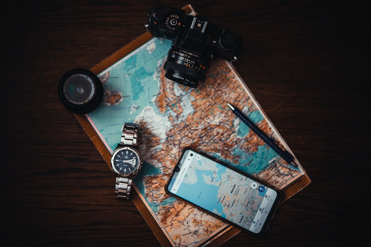googlemaps, fotoaparát, hodinky a smartphone položené na stole